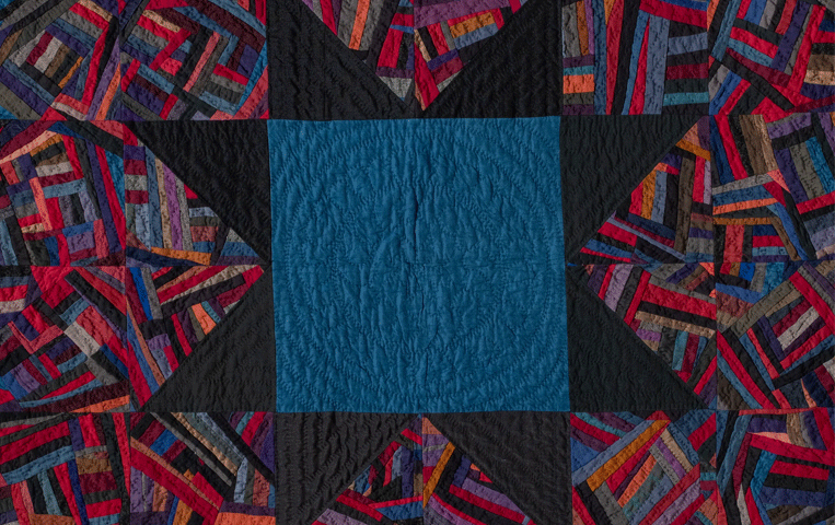 Cotton and wool quilt with a square and star at the center, along with other various geometric shapes.